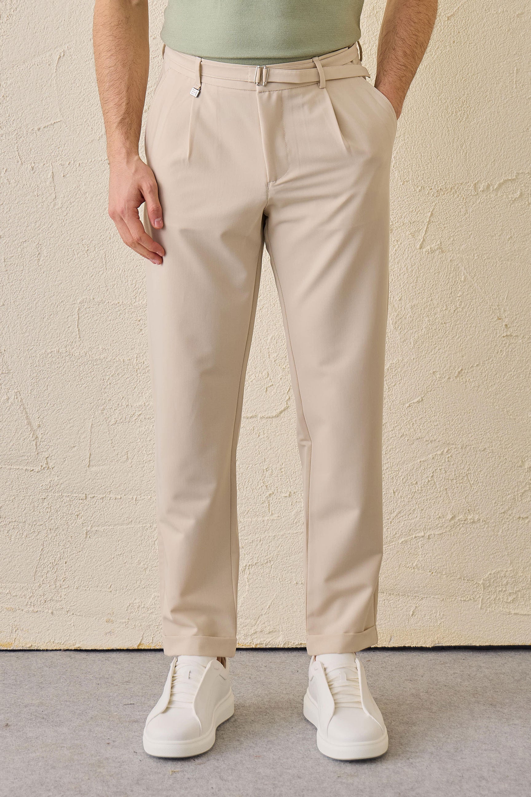 Pantaloni Gurkha da uomo beige a pieghe, con vita regolabile e vestibilità affusolata su misura.