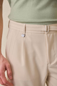 Pantaloni Gurkha da uomo beige a pieghe, con vita regolabile e vestibilità affusolata su misura.