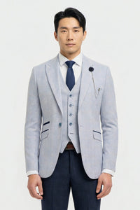 Uomo che indossa un blazer grigio chiaro, un gilet blu navy e una cravatta blu scuro su sfondo bianco