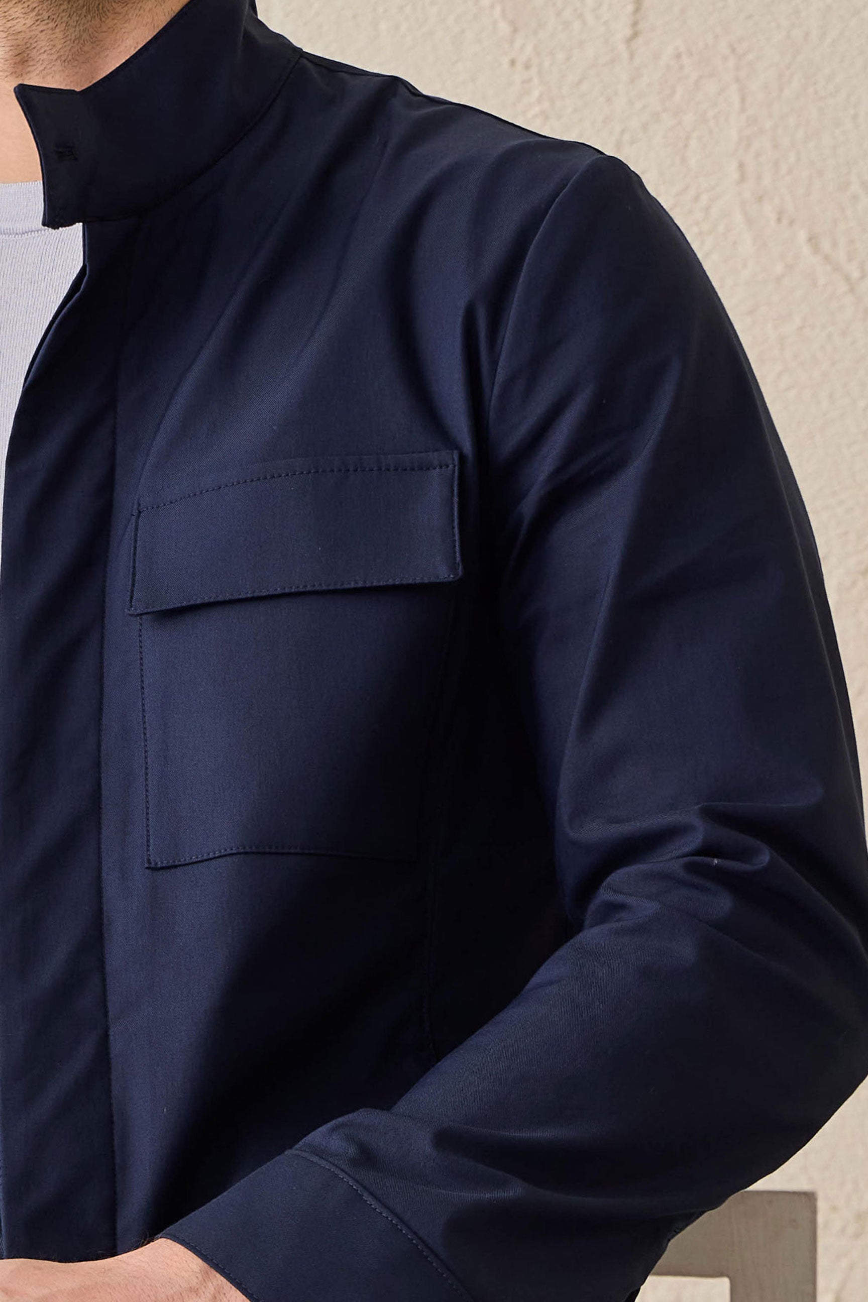Completo da uomo elegante e casual composto da giacca safari in misto cotone blu navy e pantaloni bianchi.