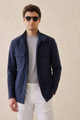 Completo da uomo elegante e casual composto da giacca safari in misto cotone blu navy e pantaloni bianchi.
