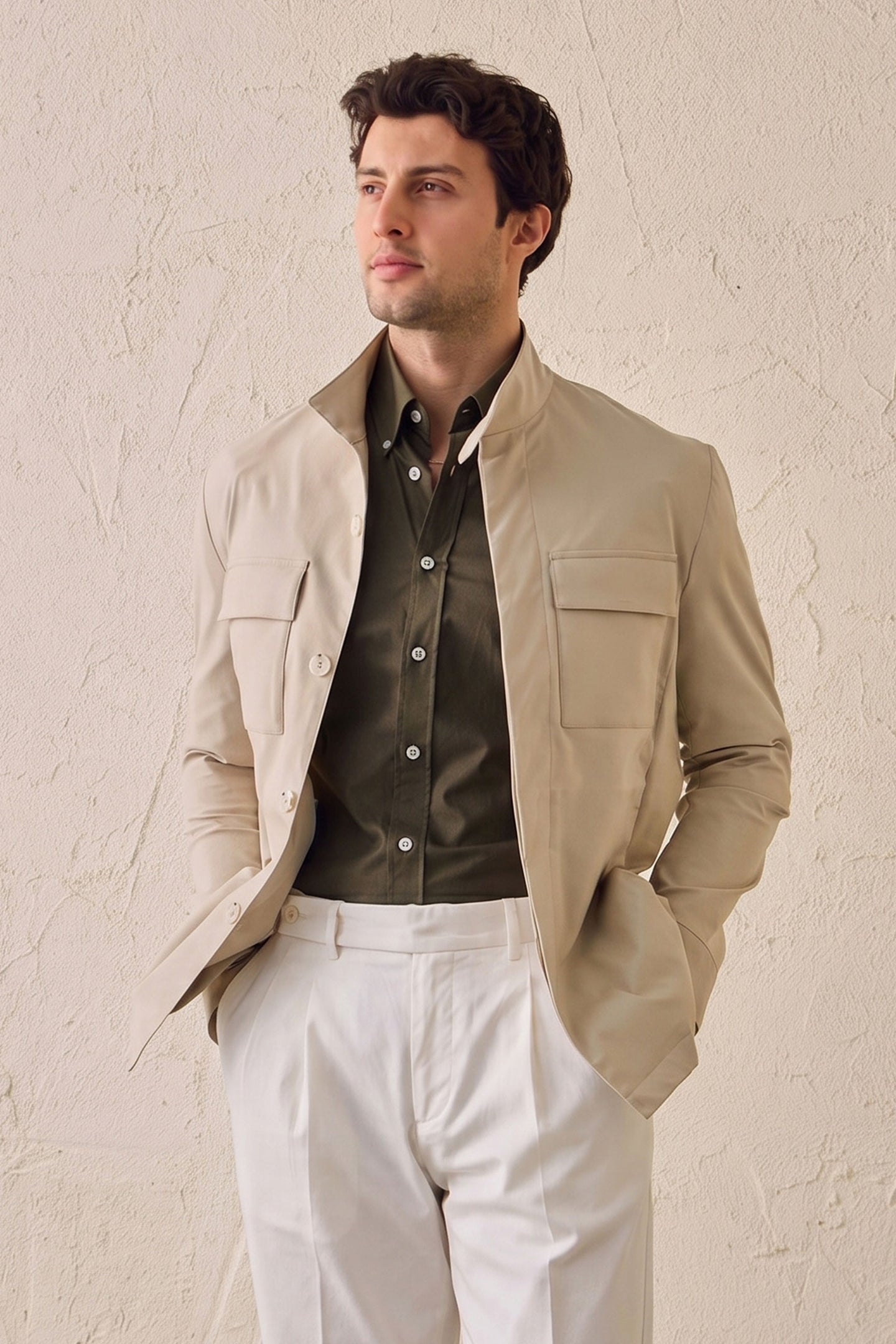Completo da uomo composto da giacca safari beige in misto cotone e pantaloni bianchi, elegante e casual.