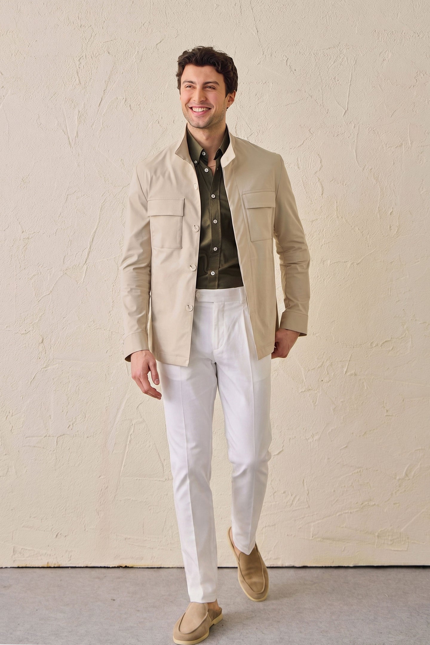 Completo da uomo composto da giacca safari beige in misto cotone e pantaloni bianchi, elegante e casual.