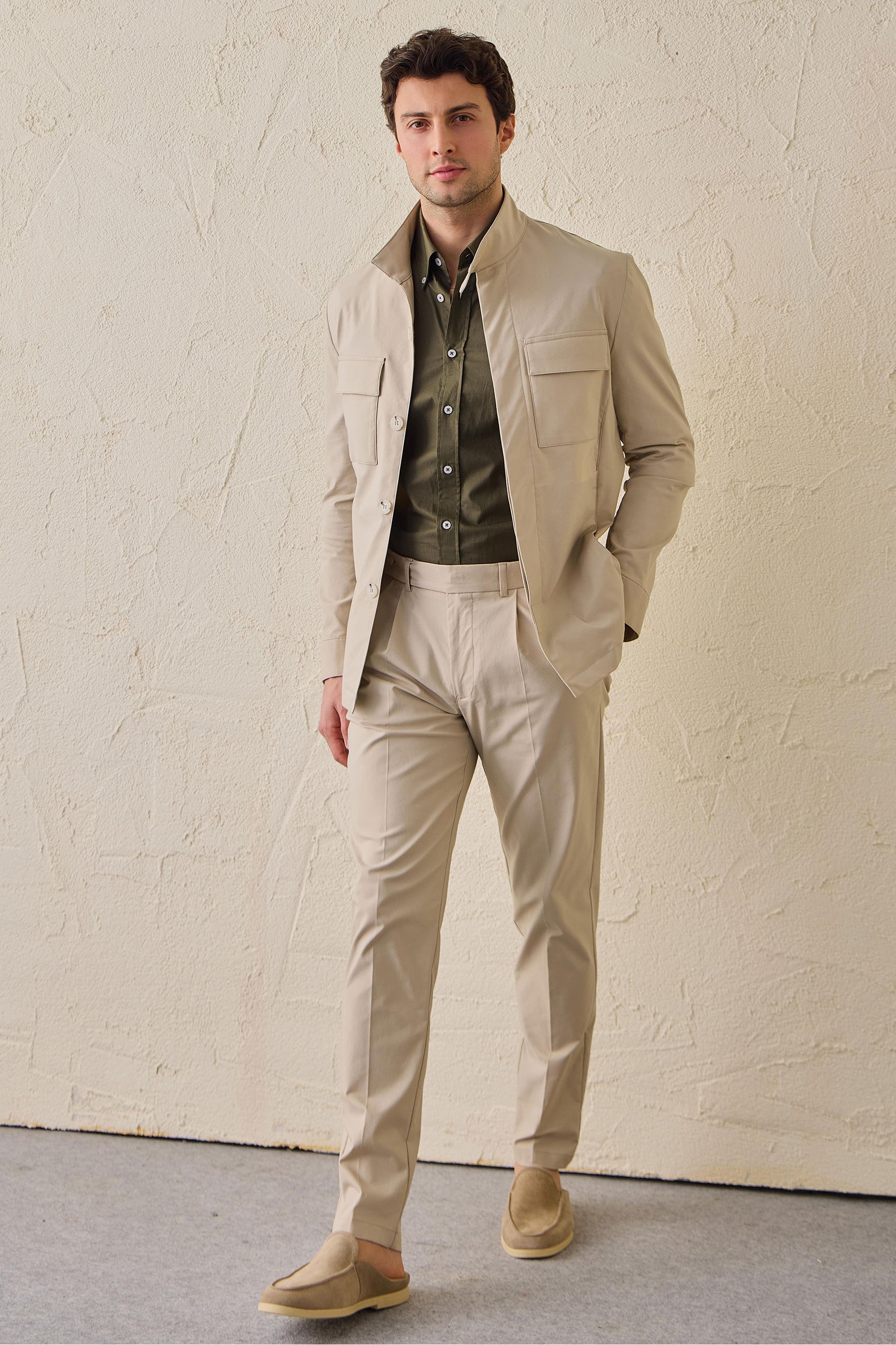 Pantaloni eleganti da uomo beige a pieghe, vestibilità classica e sartoriale.