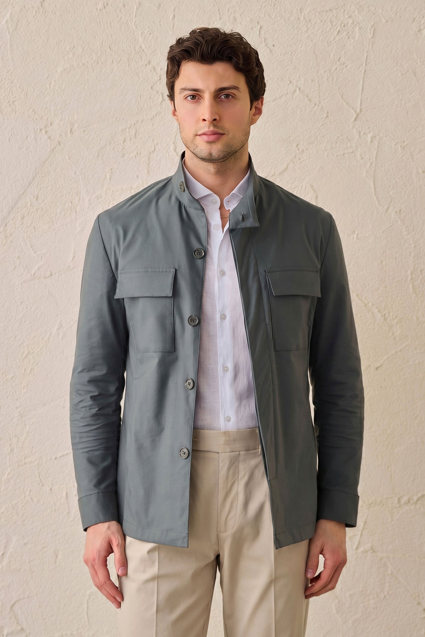 Completo da uomo elegante e casual composto da giacca safari in misto cotone verde salvia e pantaloni beige.