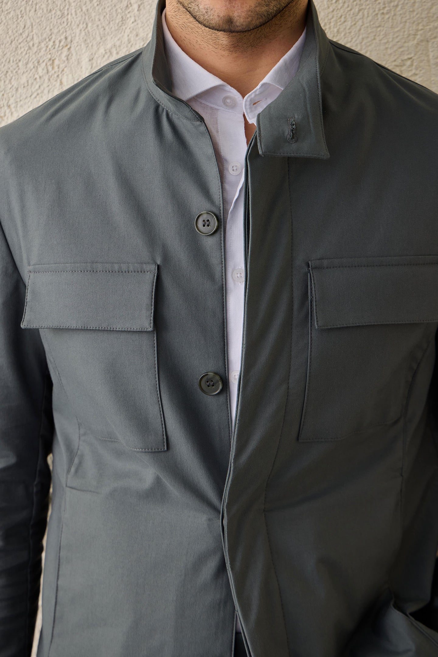 Completo da uomo elegante e casual composto da giacca safari in misto cotone verde salvia e pantaloni beige.