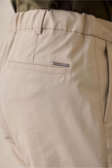 Pantaloni eleganti da uomo beige a pieghe, vestibilità classica e sartoriale.
