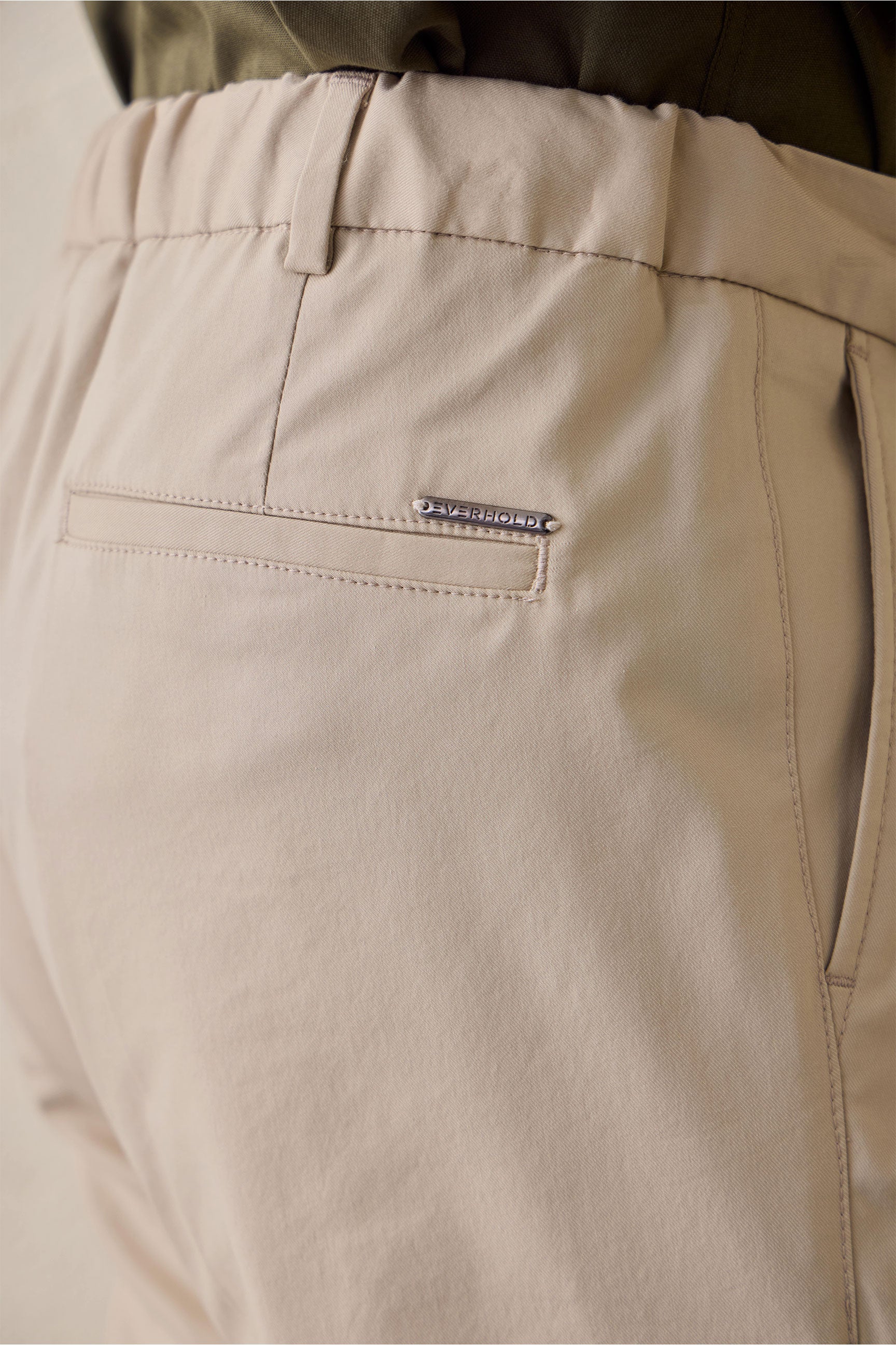 Pantaloni eleganti da uomo beige a pieghe, vestibilità classica e sartoriale.