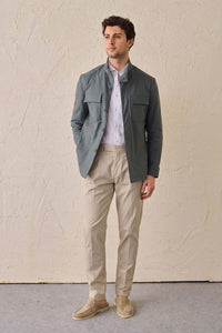 Completo da uomo elegante e casual composto da giacca safari in misto cotone verde salvia e pantaloni beige.