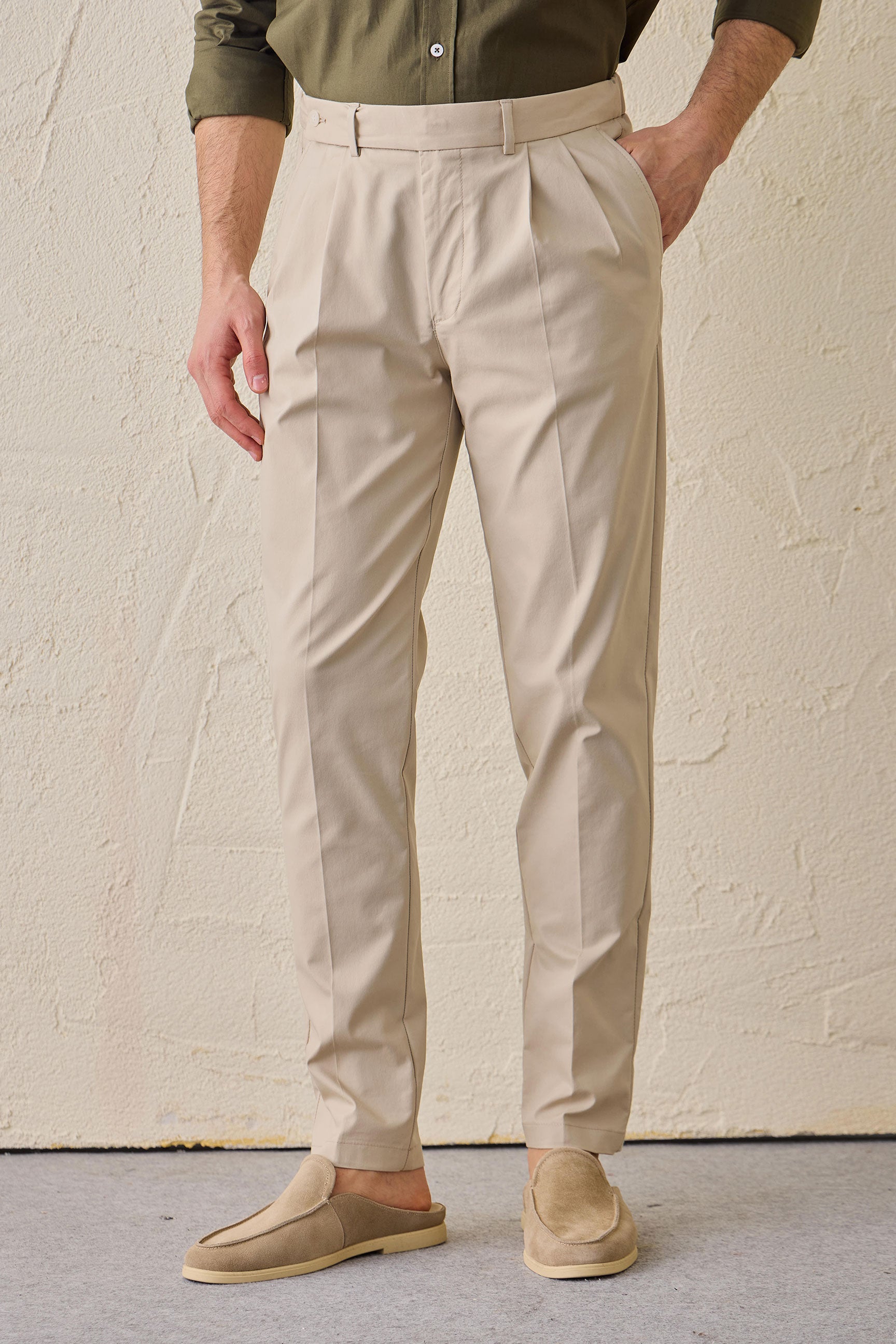 Pantaloni eleganti da uomo beige a pieghe, vestibilità classica e sartoriale.