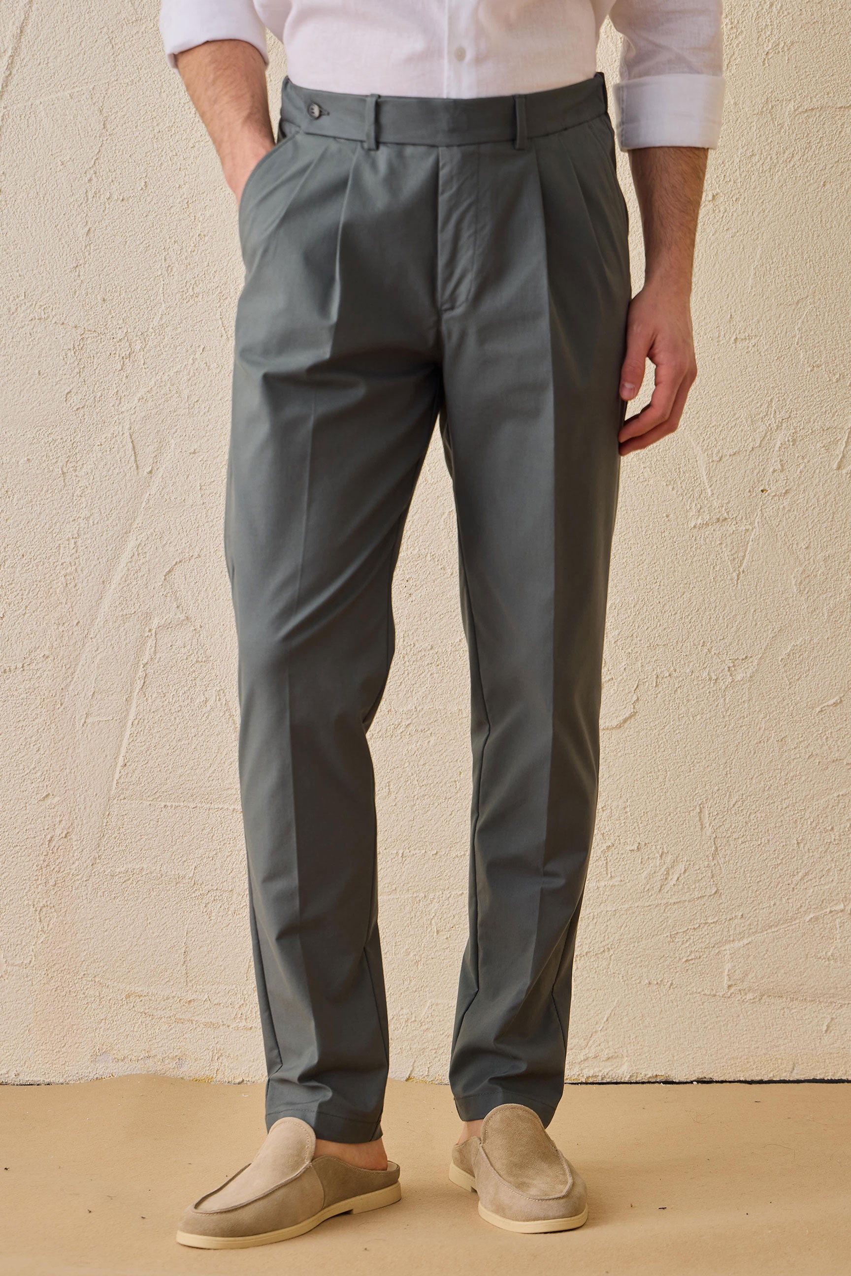Pantaloni eleganti casual da uomo color verde salvia con pieghe, vestibilità classica sartoriale.