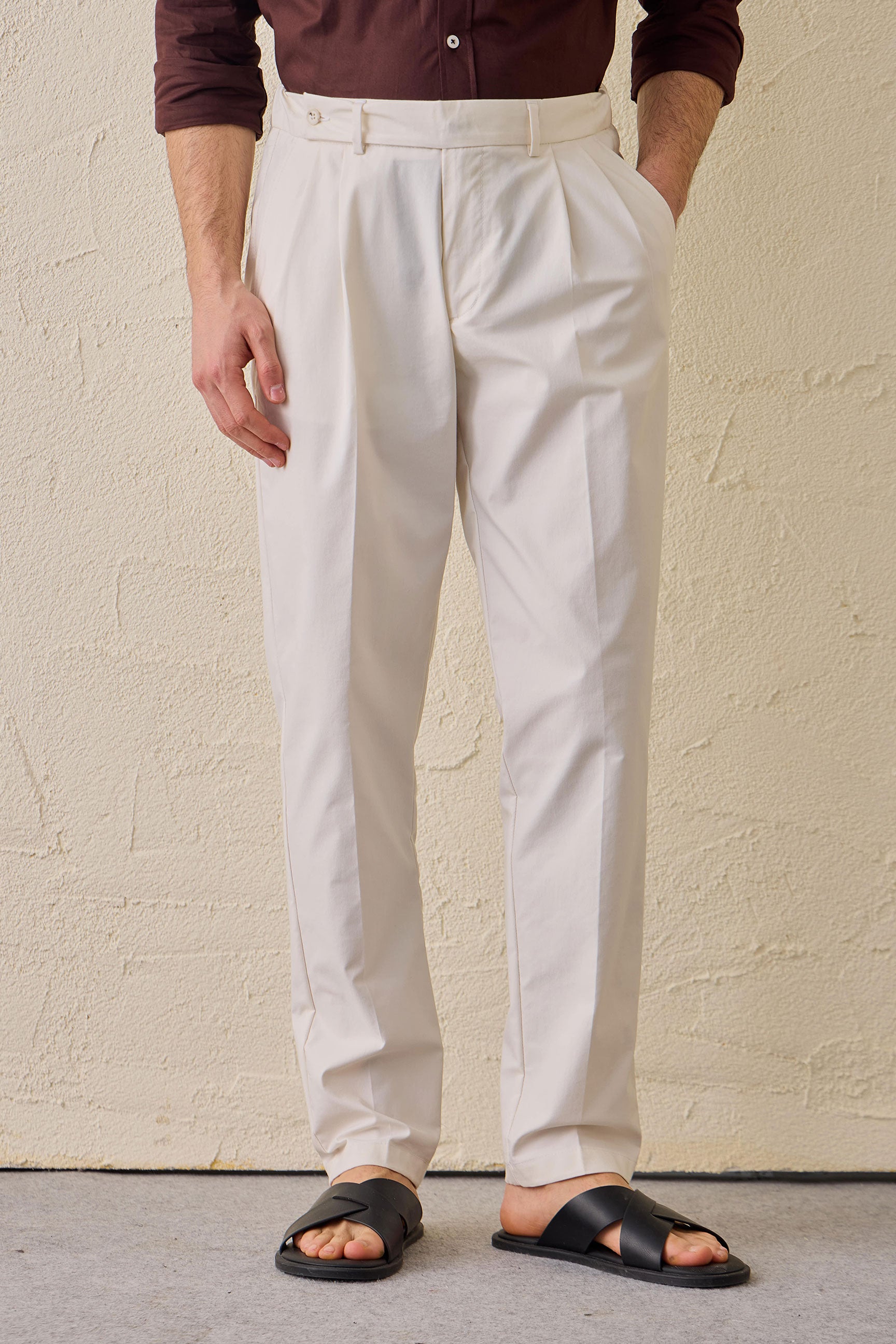Pantaloni eleganti da uomo bianchi a pieghe, vestibilità classica sartoriale.