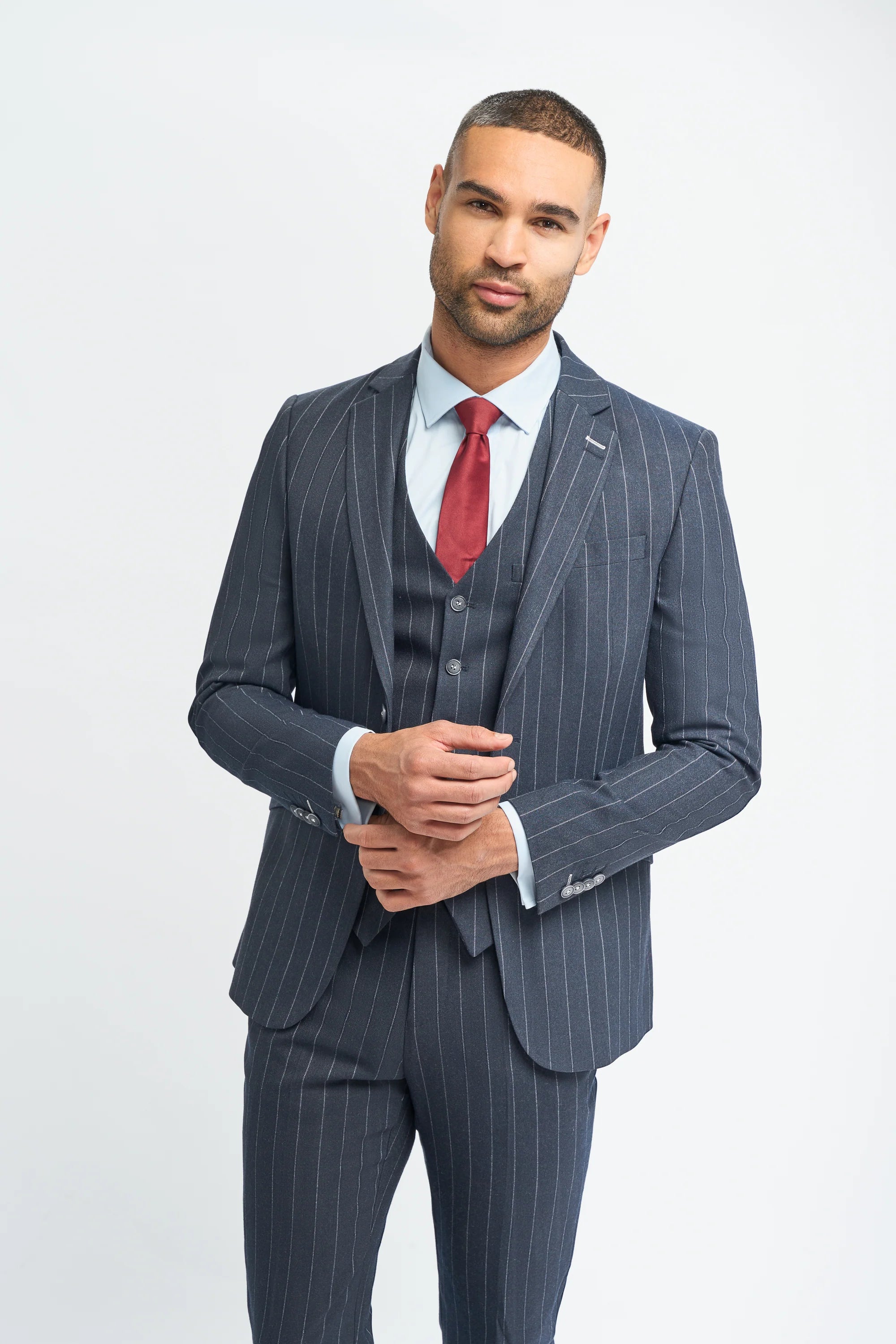 Man wearing a gray pinstripe suit with a red tie on a white background