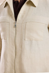Completo estivo da uomo composto da giacca in lino beige con zip e pantaloni marroni, elegante e casual.