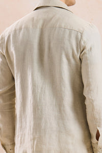 Completo estivo da uomo composto da giacca in lino beige con zip e pantaloni marroni, elegante e casual.