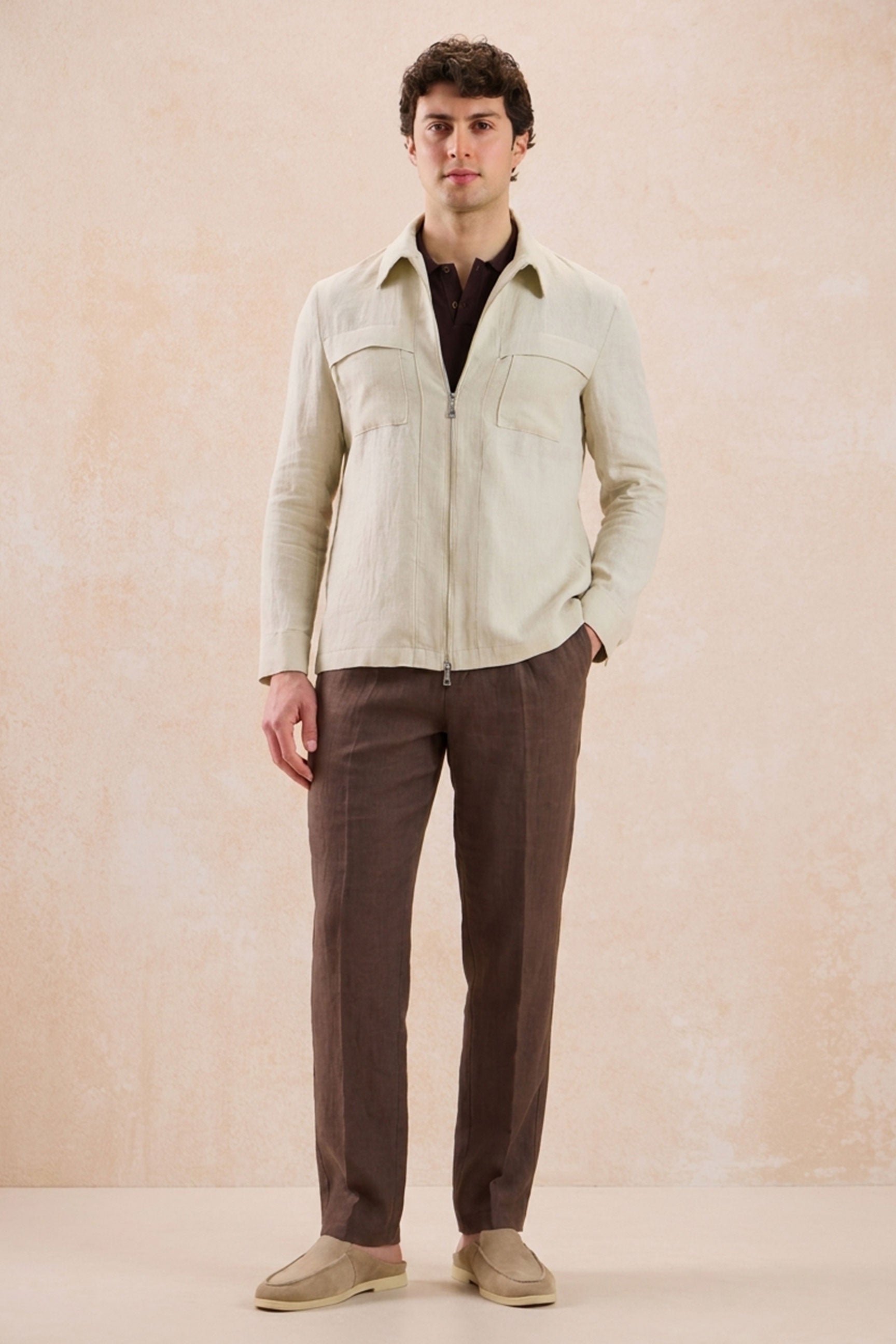 Completo estivo da uomo composto da giacca in lino beige con zip e pantaloni marroni, elegante e casual.
