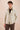 Completo estivo da uomo composto da giacca in lino beige con zip e pantaloni marroni, elegante e casual.
