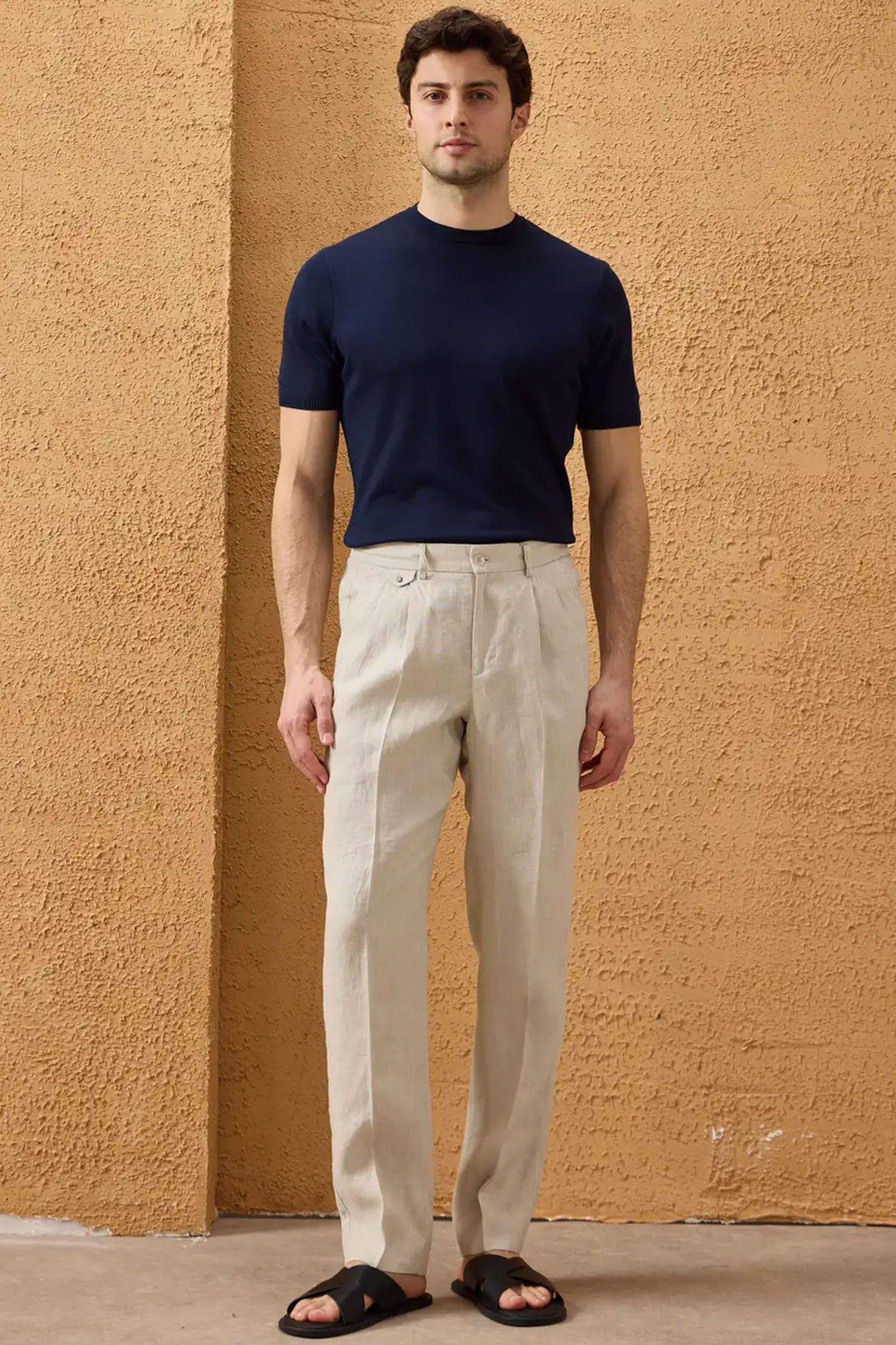 Completo estivo da uomo composto da giacca in lino nera con zip e pantaloni beige, elegante e casual.