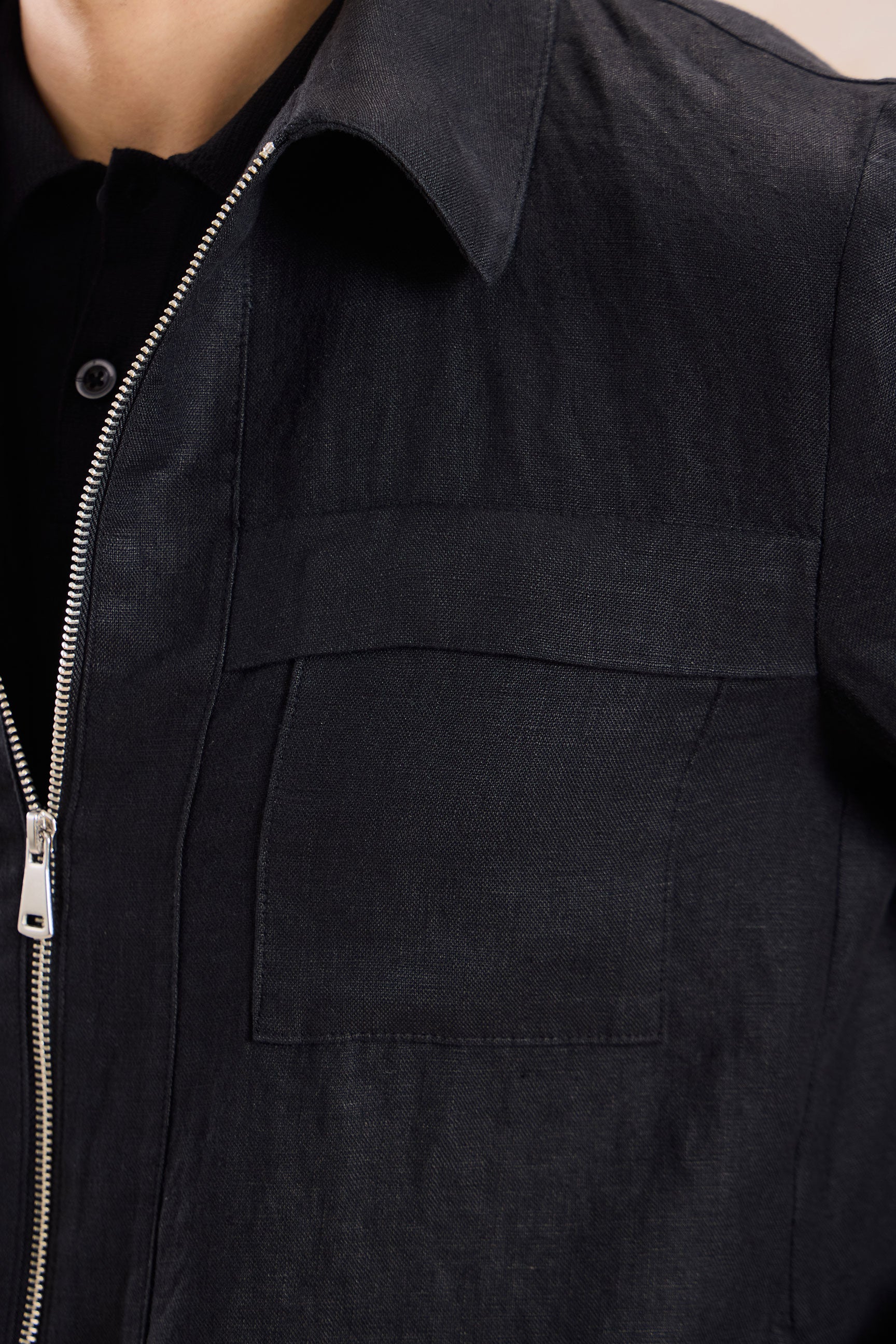 Completo estivo da uomo composto da giacca in lino nera con zip e pantaloni beige, elegante e casual.