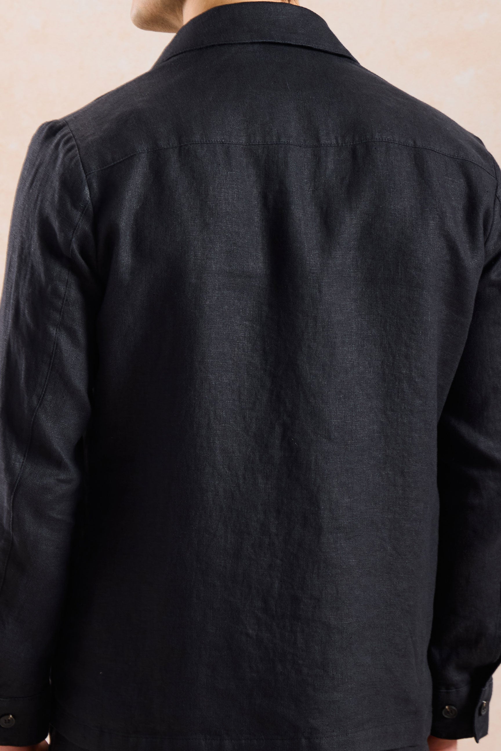 Completo estivo da uomo composto da giacca in lino nera con zip e pantaloni beige, elegante e casual.