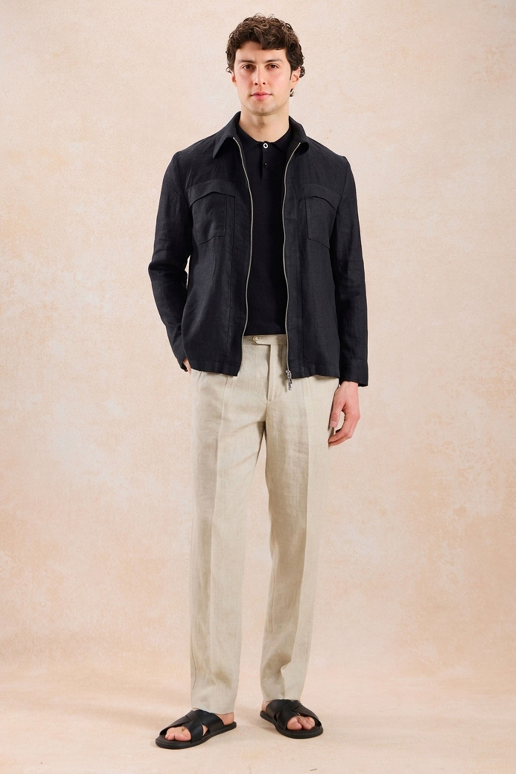 Completo estivo da uomo composto da giacca in lino nera con zip e pantaloni beige, elegante e casual.