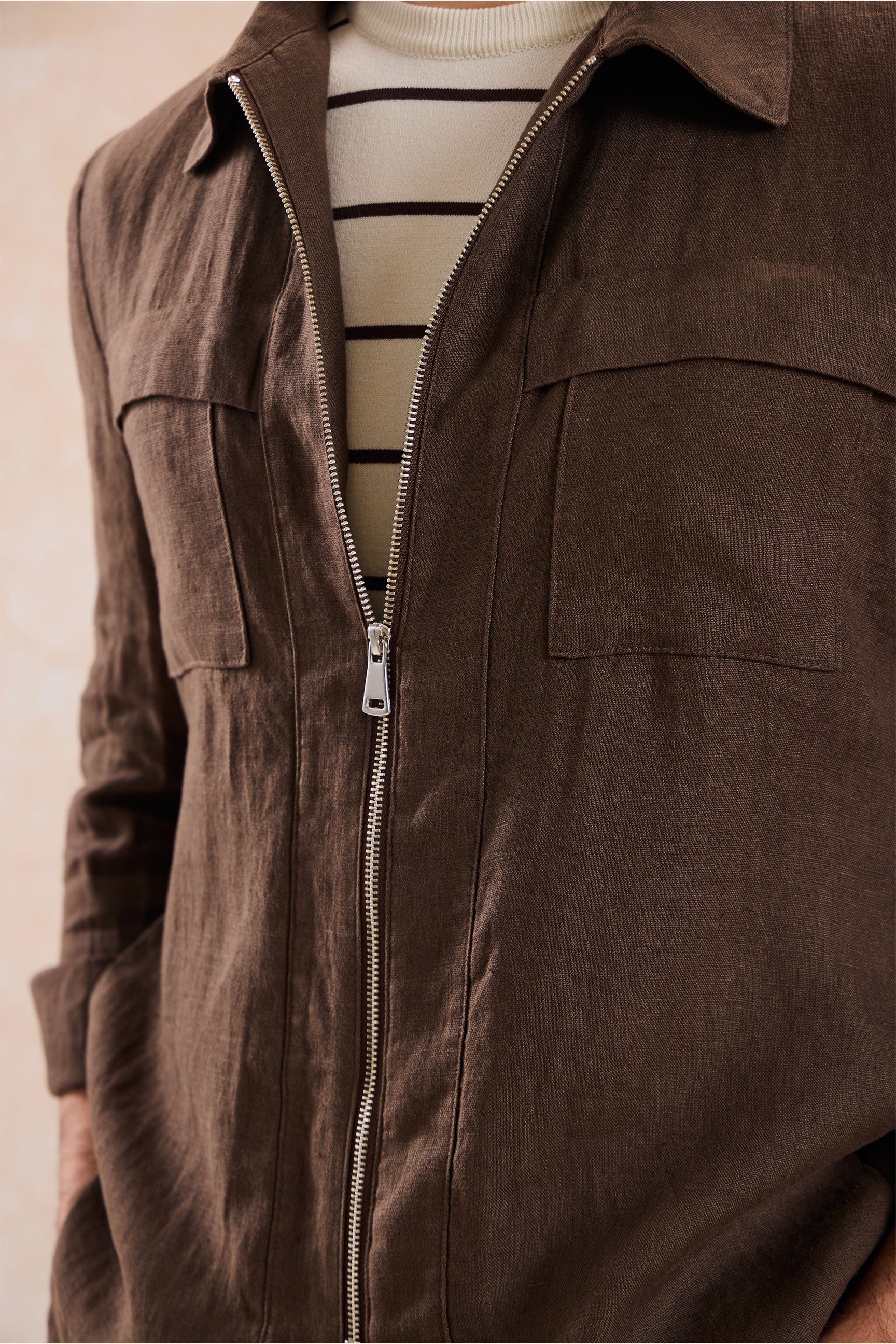 Completo estivo da uomo composto da giacca in lino marrone con zip e pantaloni beige, elegante e casual.
