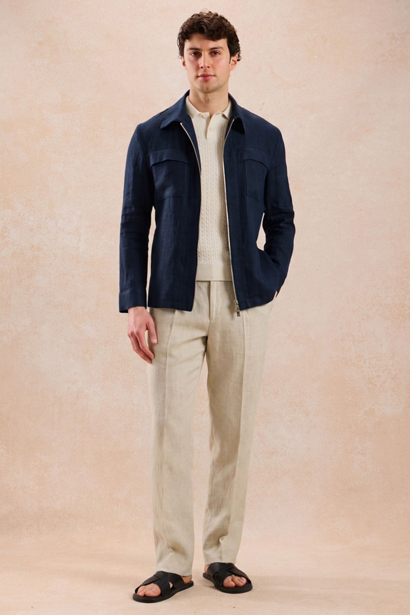 Completo estivo da uomo composto da giacca in lino blu navy con zip e pantaloni beige, elegante e casual.