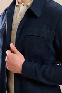 Completo estivo da uomo composto da giacca in lino blu navy con zip e pantaloni beige, elegante e casual.