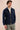 Completo estivo da uomo composto da giacca in lino blu navy con zip e pantaloni color salvia, elegante e casual.