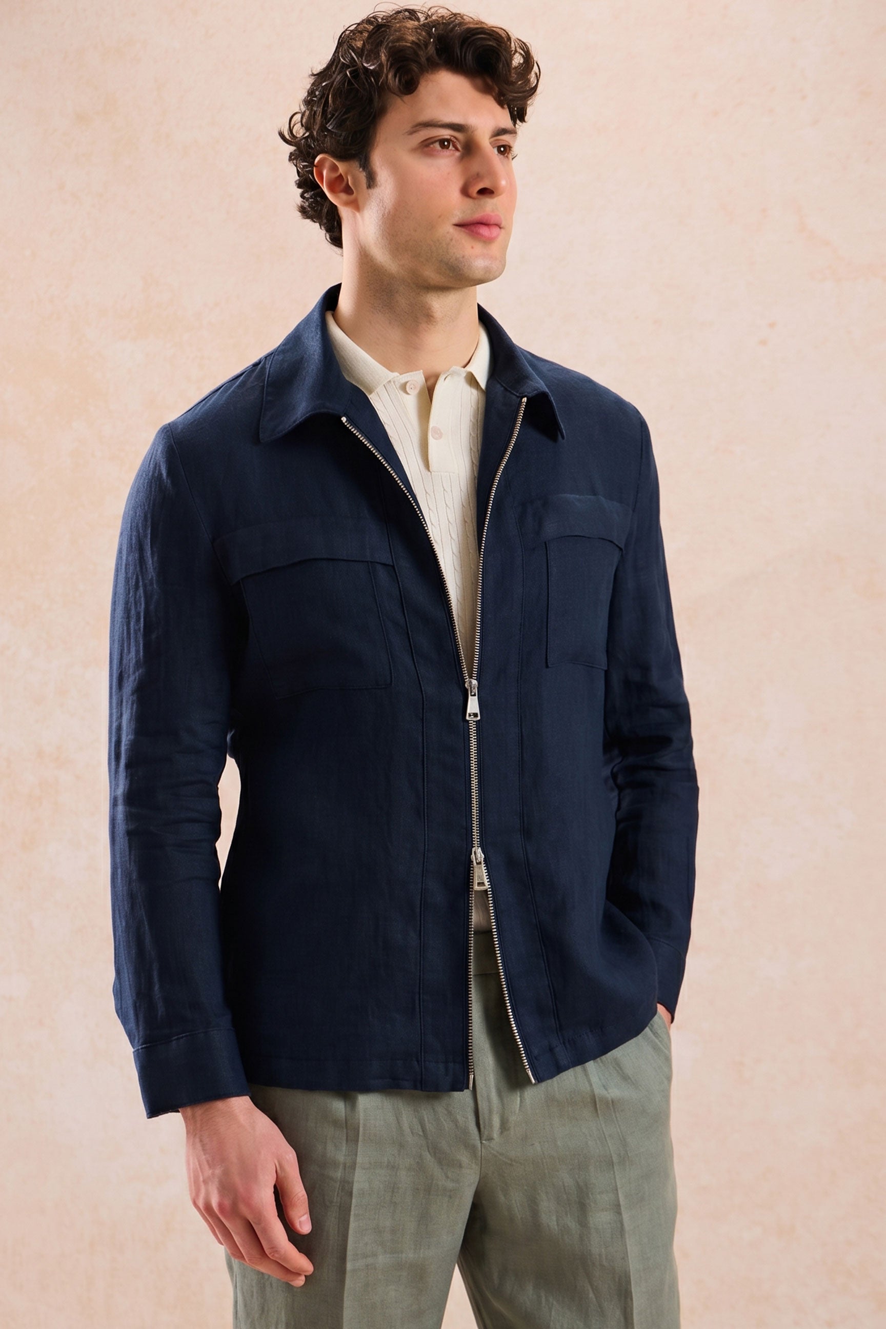 Completo estivo da uomo composto da giacca in lino blu navy con zip e pantaloni color salvia, elegante e casual.