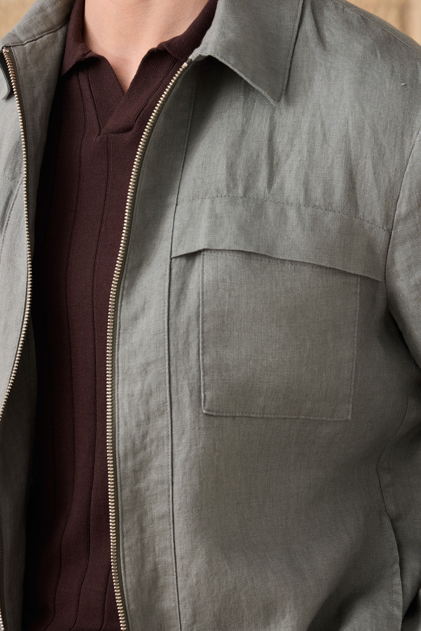 Completo estivo da uomo composto da giacca in lino verde salvia con zip e pantaloni beige, elegante e casual.