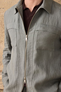 Completo estivo da uomo composto da giacca in lino verde salvia con zip e pantaloni beige, elegante e casual.