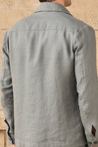 Completo estivo da uomo composto da giacca in lino verde salvia con zip e pantaloni beige, elegante e casual.