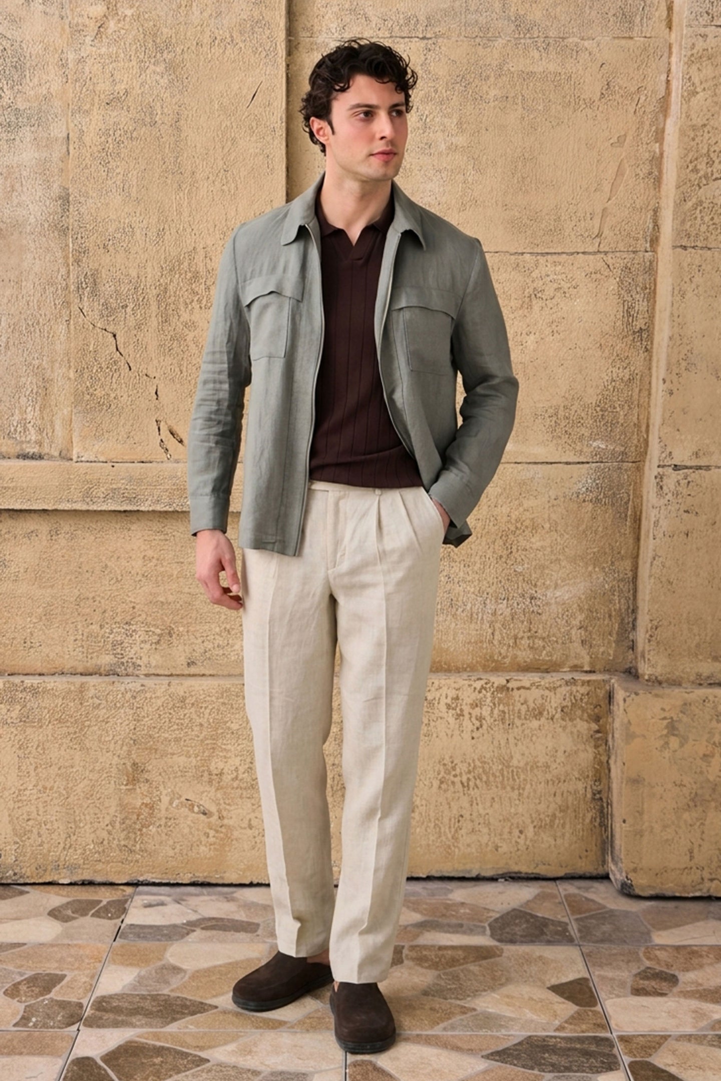 Completo estivo da uomo composto da giacca in lino verde salvia con zip e pantaloni beige, elegante e casual.