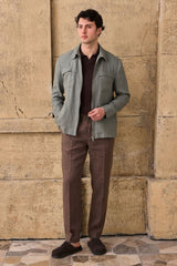 Completo estivo da uomo composto da giacca in lino verde salvia con zip e pantaloni marroni, elegante e casual.