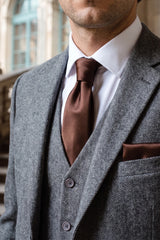Set da uomo con cravatta marrone, fazzoletto da taschino e gemelli.