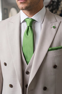 Set da uomo con cravatta verde, fazzoletto da taschino e gemelli abbinati.