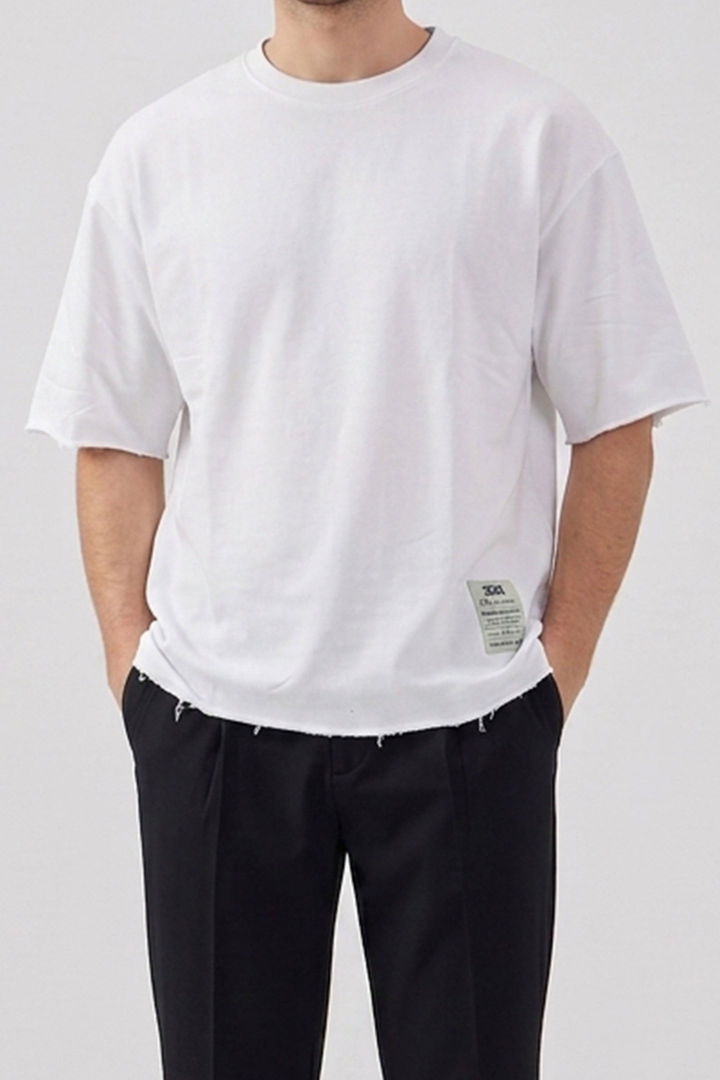 T-shirt da uomo bianca a vestibilità comoda con orlo sfrangiato, in misto cotone, girocollo.